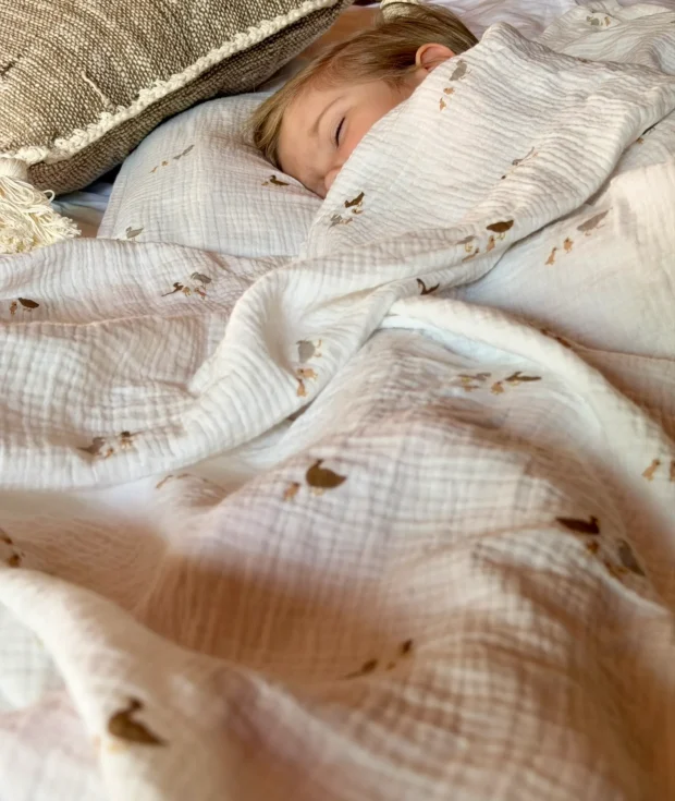 Baby wrapped in ducks muslin swaddle blanket – soft cotton newborn wrap with duck print, handmade by HomeyMuslin