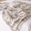 Close-up of jungle muslin swaddle blanket fabric – soft cotton weave with animal print, newborn safe, handmade